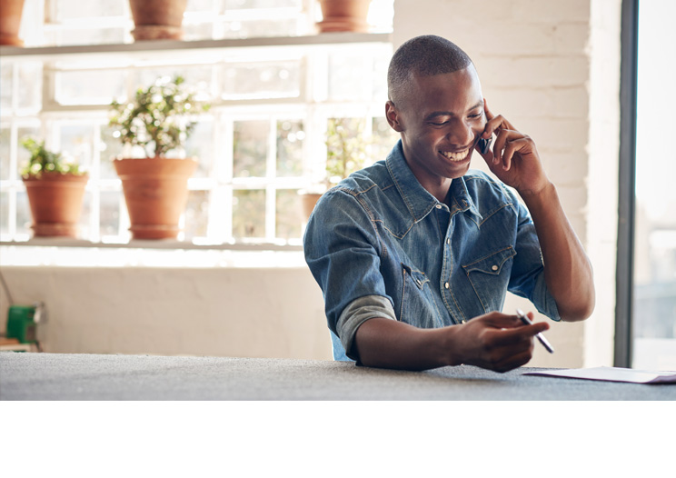 Professional Smiling while on the phone with a pen in his hand
